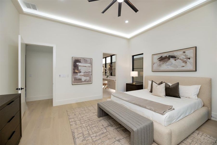 Bedroom with light wood finished floors, ceiling fan, recessed lighting, and ensuite bath