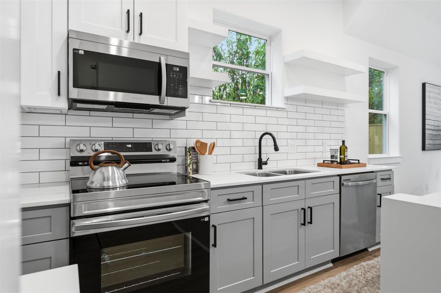 Open concept kitchen, dining and living room, with lots of natural light.