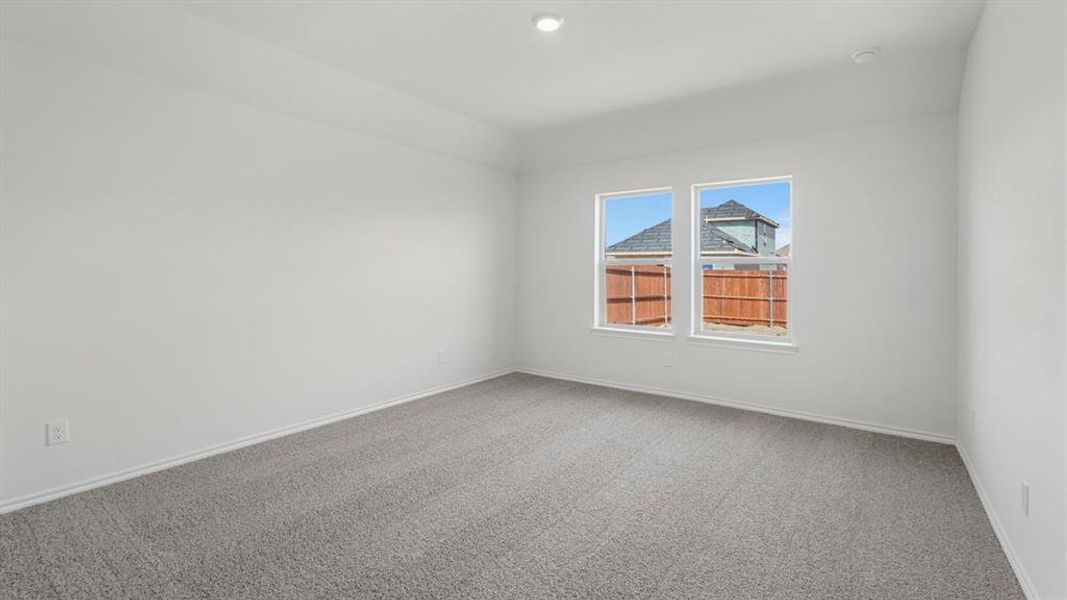 Spacious room featuring neutral carpeting, white walls, two windows, and recessed lighting