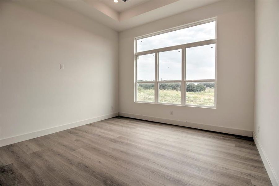 Spare room with light wood-style flooring and baseboards Spare room with light wood-style flooring and baseboards