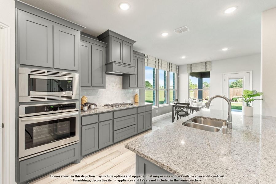 Kitchen with gray cabinets, granite island, stainless steel appliances, and large windows overlooking a dining area