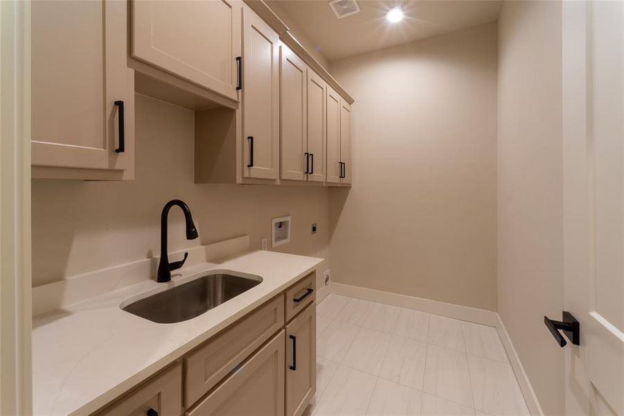 Laundry with sink and lots of storage.