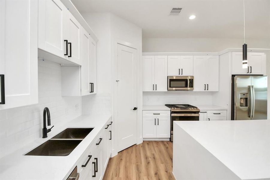 Step into the dream kitchen you've always wanted! This generously spacious culinary haven features a massive granite island, high ceilings, soft-close cabinets, granite countertops, stainless steel appliances, a sleek tile backsplash, and recessed lighting. The extended counter area seamlessly blends style with practicality. As it all unfolds, the kitchen opens up to the expansive family room, creating a perfect hub for gatherings and making every meal a social event.