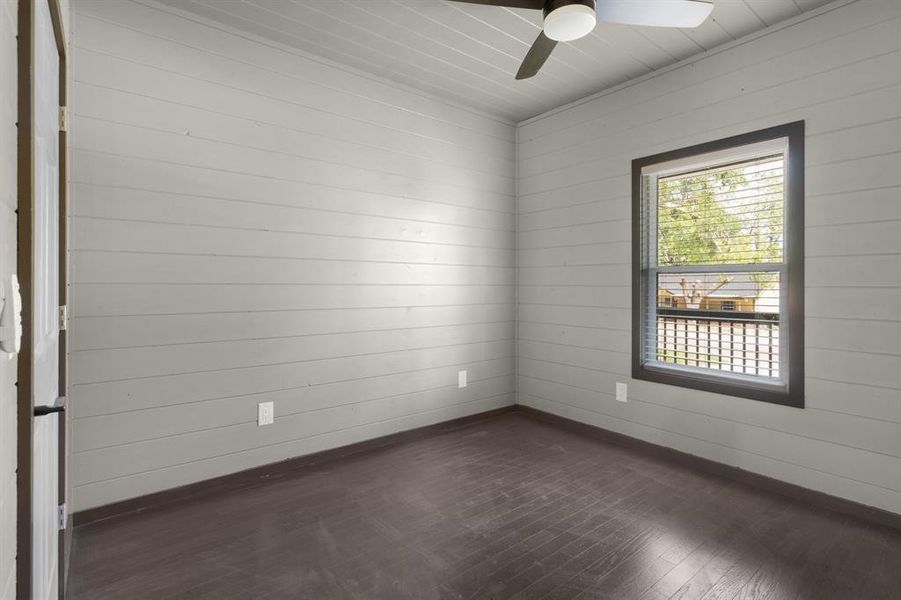 Spare room featuring baseboards, dark wood-type flooring, and ceiling fan Spare room featuring baseboards, dark wood-type flooring, and ceiling fan