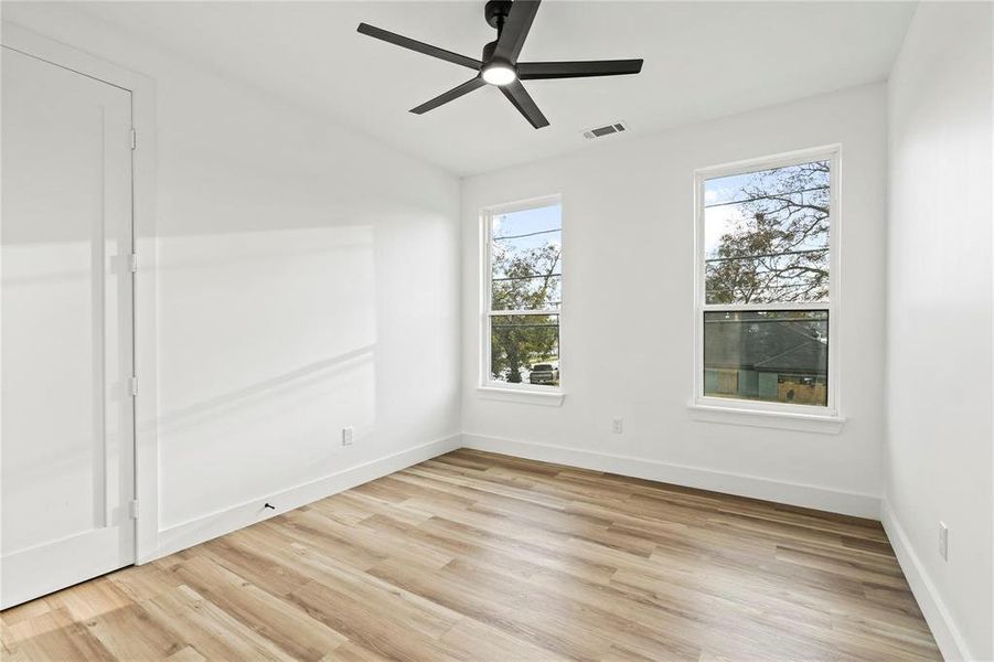 Empty room featuring light wood finished floors and ceiling fan