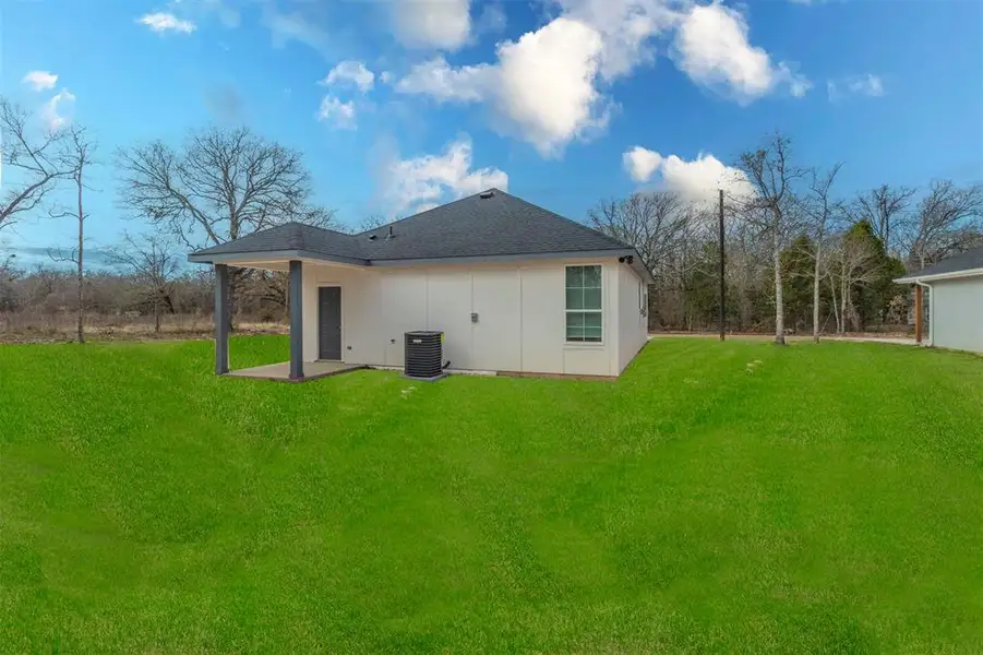 Back of property featuring a patio, central AC, and a lawn