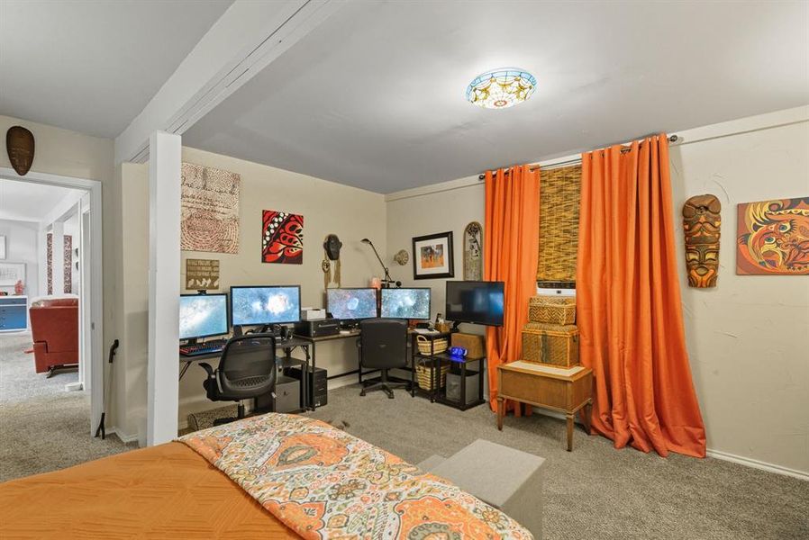 Bedroom featuring light colored carpet and an office area Bedroom featuring light colored carpet and an office area