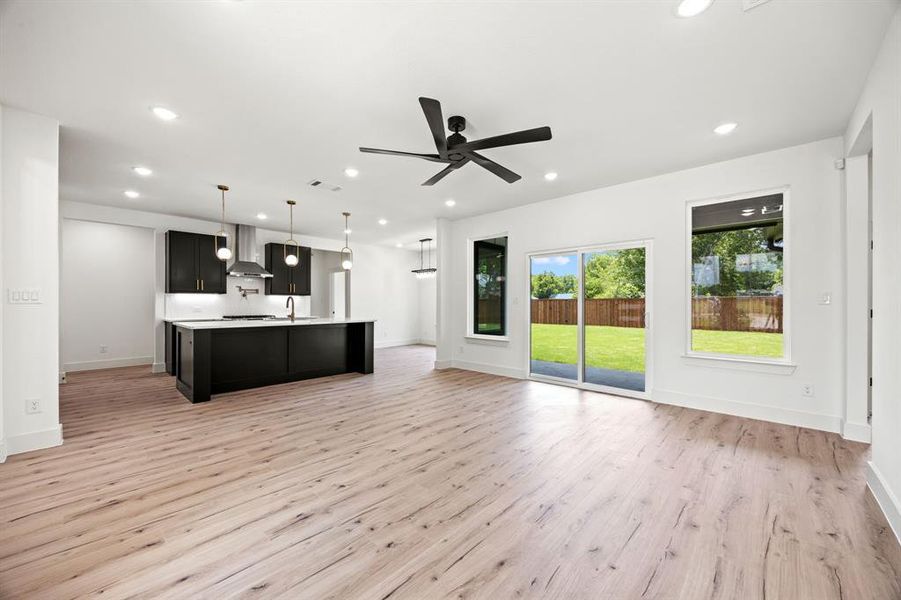 Unfurnished living room with a sink, light wood-style floors, recessed lighting, a ceiling fan, and baseboards Unfurnished living room with a sink, light wood-style floors, recessed lighting, a ceiling fan, and baseboards