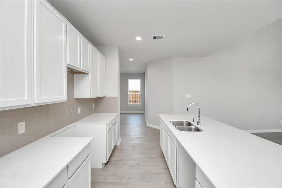 The extended counter area adds both practicality and style, making meal preparation a breeze. Every detail is thoughtfully designed to enhance the kitchen's functionality and aesthetic appeal.  Sample photo of completed home with similar plan. As built color and selections may vary.