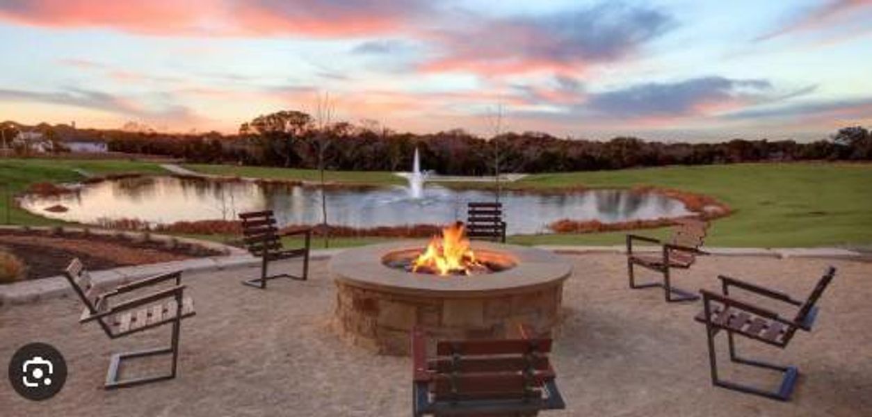 Outdoor fire pit area featuring a stone-clad fire pit, surrounding seating, and gravel hardscaping Outdoor fire pit area featuring a stone-clad fire pit, surrounding seating, and gravel hardscaping