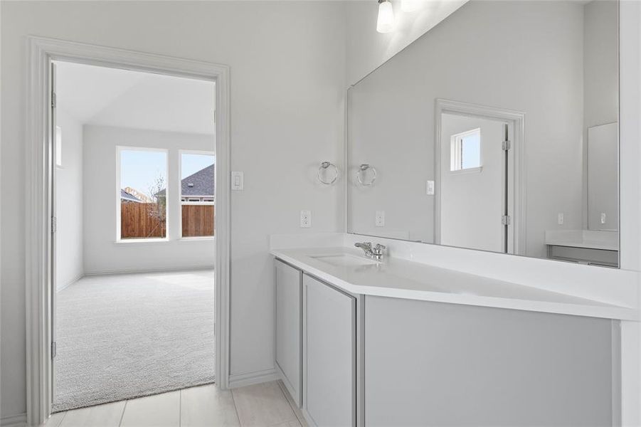 Bathroom with vanity, light colored carpet, and light tile patterned floors