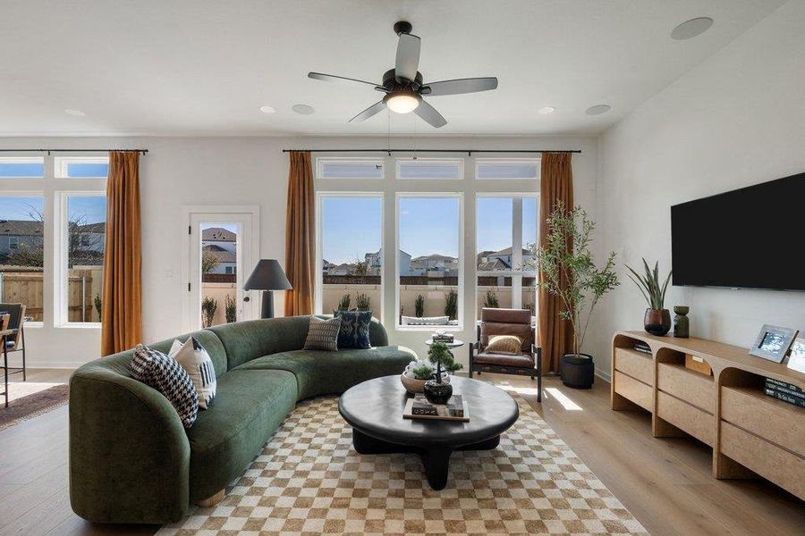 Spacious living area featuring large picture windows, wood-finish flooring, and recessed lighting