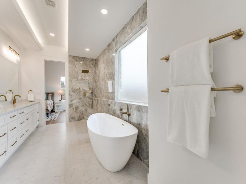 Bathroom with tile walls, a bathing tub, and vanity