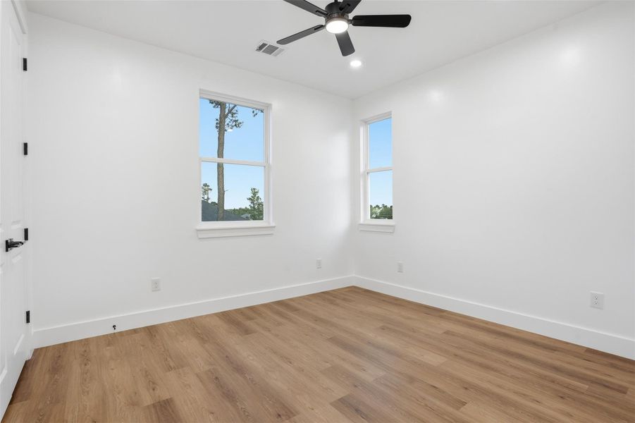 Spare room featuring light wood-style floors, a ceiling fan, and recessed lighting