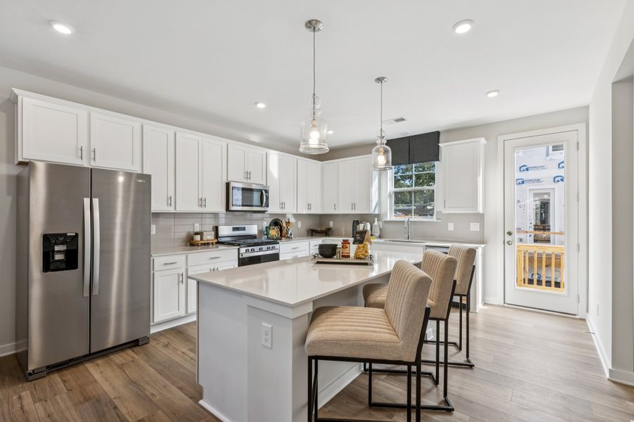 A kitchen with white cabinets.