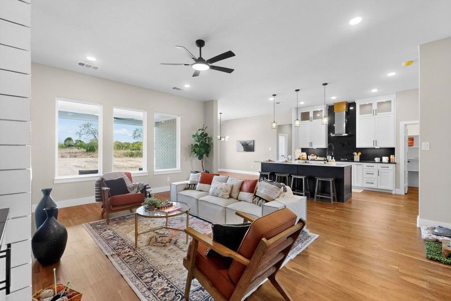 Living room featuring light wood-type flooring, a ceiling fan, and recessed lighting