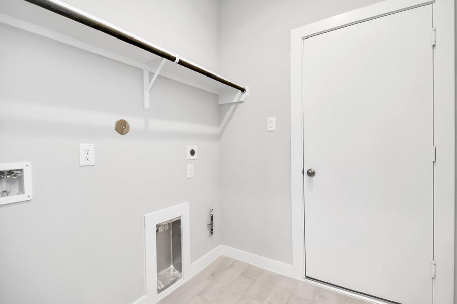 A spacious utility room with ample shelving for organization. It features connections forboth gas and electric dryers, making it versatile and functional for all laundry needs. Sample photo of completed home with similar floor plan. Actual colors and selections may vary.