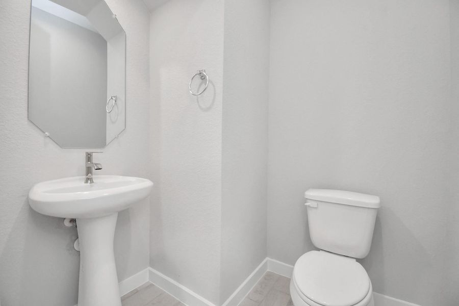 This half bathroom features a stylish pedestal sink, modern hardware, and bright recessed lighting, creating a sleek and inviting space. This half bathroom features a stylish pedestal sink, modern hardware, and bright recessed lighting, creating a sleek and inviting space.