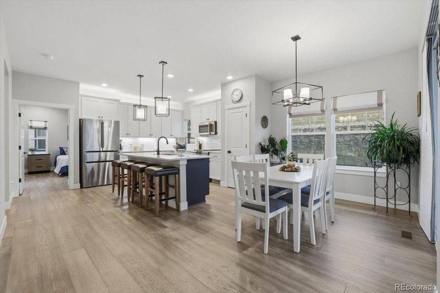The kitchen and dining area are filled with natural light thanks to the large windows and sliding glass door.