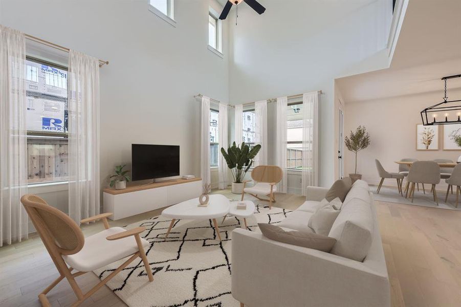 Virtually staged photo - Living area featuring wood finished floors, a high ceiling, and ceiling fan Virtually staged photo - Living area featuring wood finished floors, a high ceiling, and ceiling fan