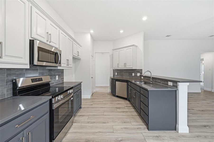 Two-toned cabinets with a stainless steel appliance package give this kitchen dimension and visual appeal Two-toned cabinets with a stainless steel appliance package give this kitchen dimension and visual appeal