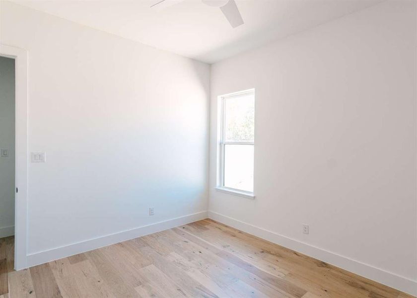 Spare room featuring ceiling fan and light hardwood / wood-style flooring