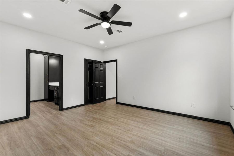 Master bedroom with ceiling fan and light hardwood / wood-style floors