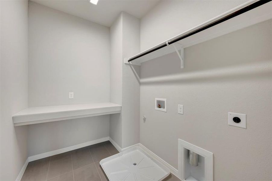 Laundry room featuring hookup for a gas dryer, washer hookup, electric dryer hookup, and dark tile patterned floors
