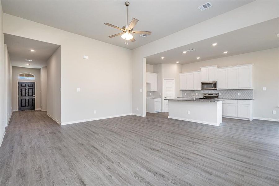 Unfurnished living room featuring light hardwood / wood-style flooring and ceiling fan