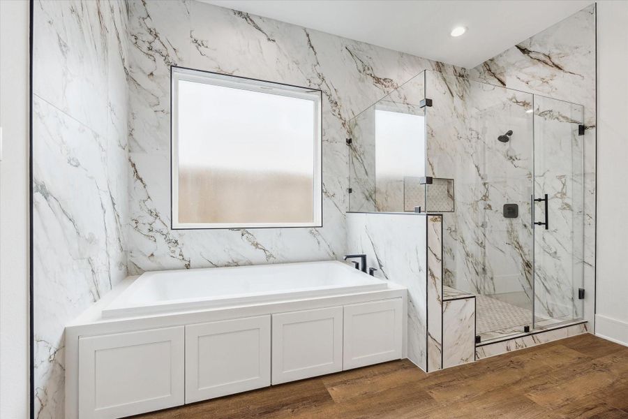 Experience a stunning primary bathroom that truly wows, complete with an expansive walk-in shower featuring a comfortable seat and a luxurious six-foot soaker tub for ultimate relaxation.