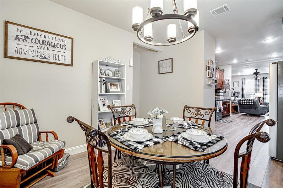 Dining space with light wood-type flooring and a chandelier