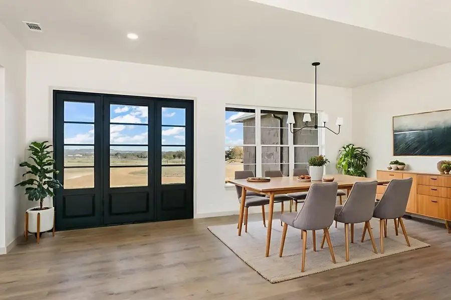 Dining area with a chandelier and light wood-type flooring Dining area with a chandelier and light wood-type flooring