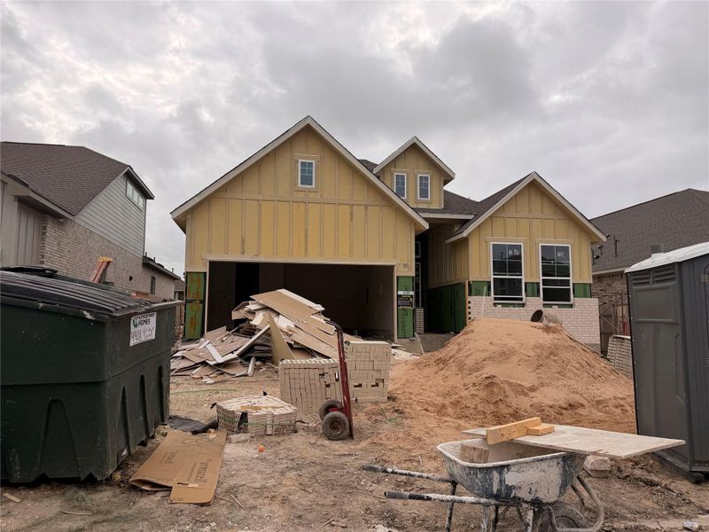 A new construction home with brick and wood siding under a cloudy sky.