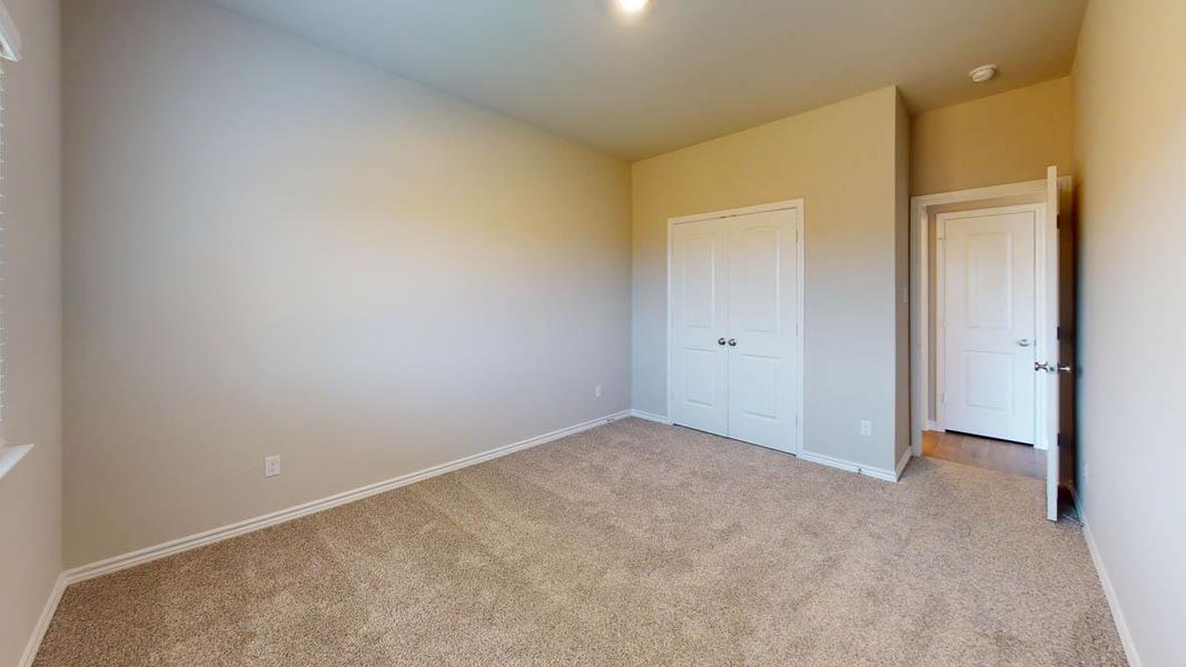 Unfurnished bedroom with carpet floors and a closet Unfurnished bedroom with carpet floors and a closet