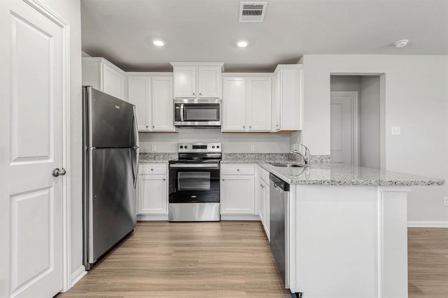 The kitchen is upgraded with Whirlpool appliances and granite countertops.