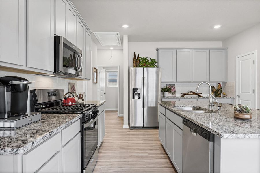 Polished stone countertops pair with clean cabinetry in this open culinary space.