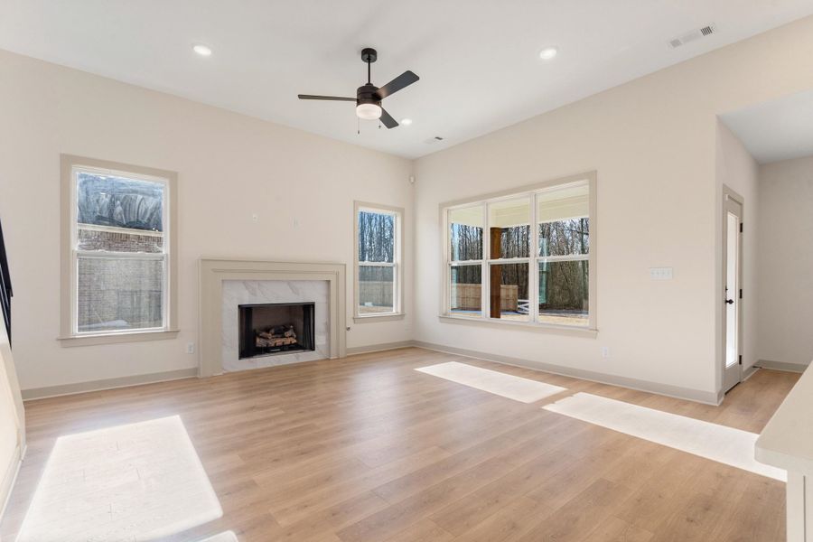 Unfurnished living room with a ceiling fan, light wood finished floors, a fireplace, and recessed lighting