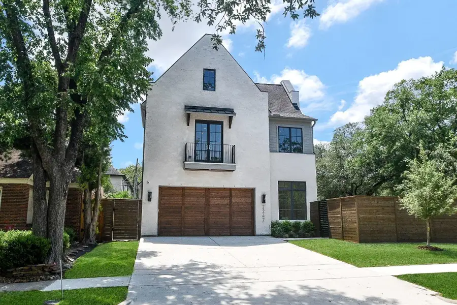 This modern three-story home features brick with Slurry finish. large windows, Extra wide driveway leading to Oversized Garage door insulated Red Cedar Overlay Garage Door
