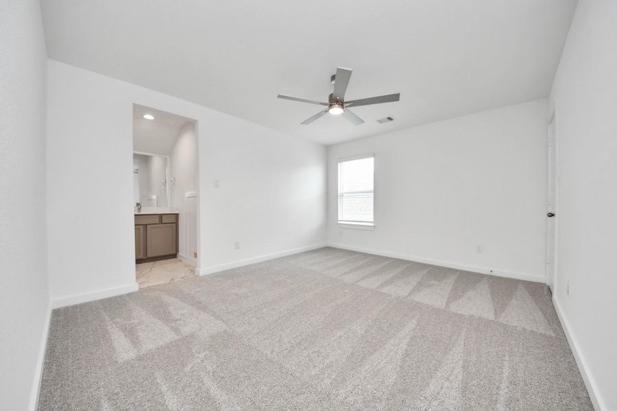 Secondary bedroom features plush carpeting, large windows that let in plenty of natural light, bright paint, and spacious closets. Sample photo of completed home with similar floor plan. Actual colors and selections may vary.