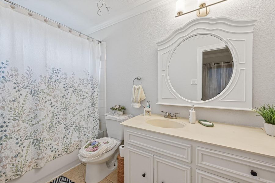 Second-level full bath featuring extended vanity, framed mirror, and shower-tub combination.