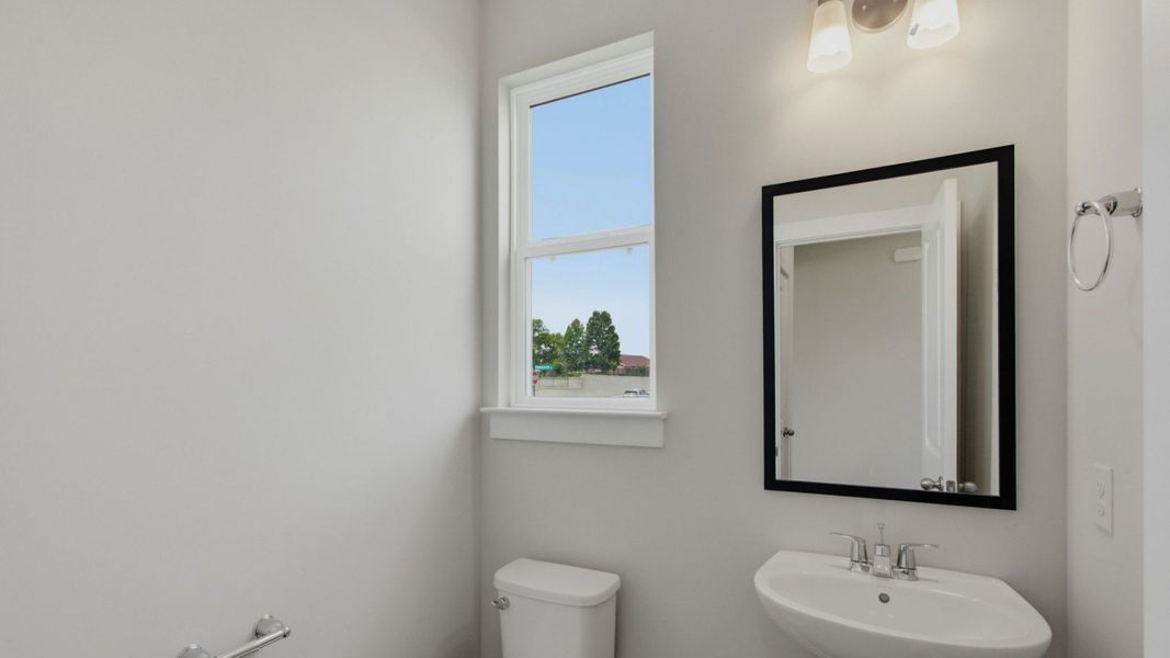 Powder room with pedestal sink on first floor