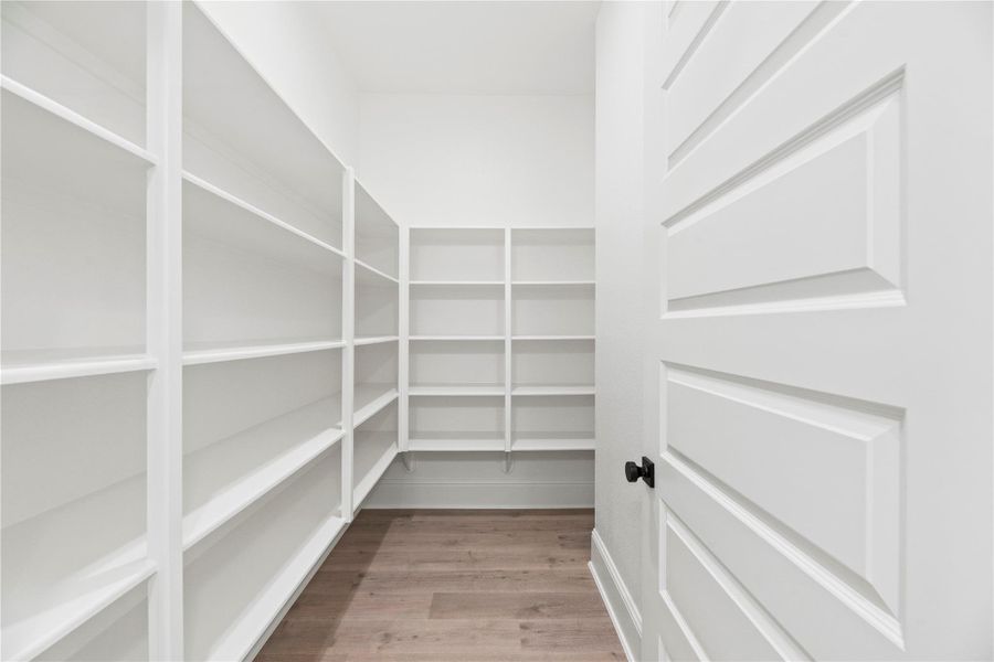 Oversized walk-in pantry with built-in shelving offers abundant storage and effortless organization.
