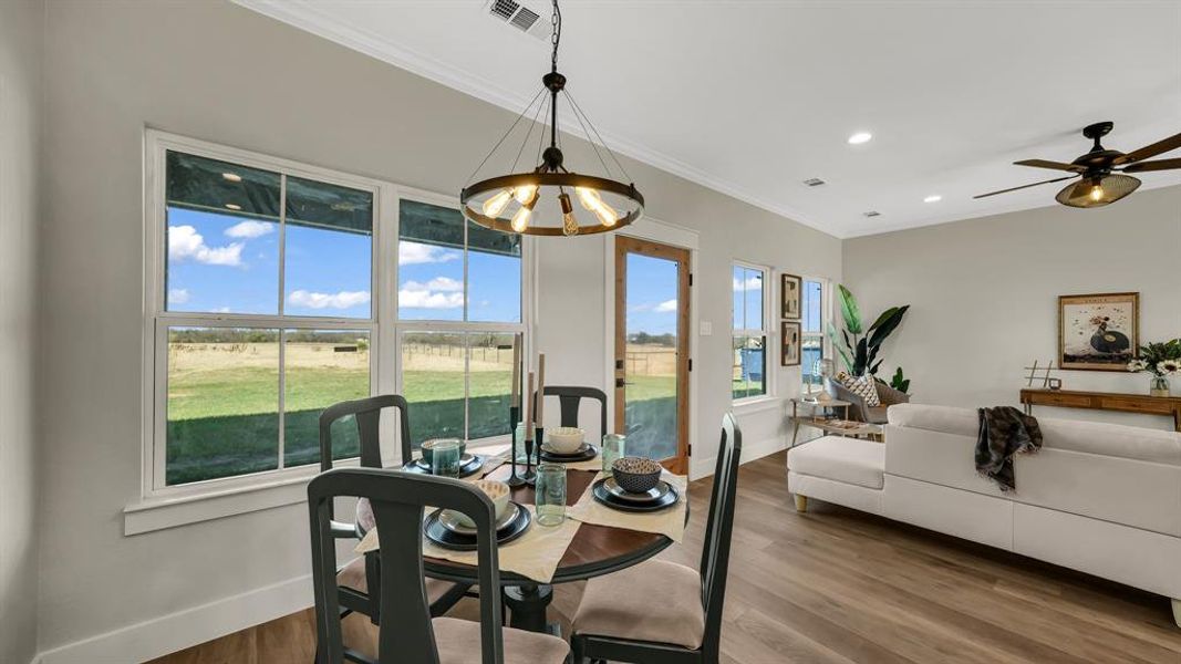 Dining space with crown molding, wood finished floors, recessed lighting, ceiling fan, and a chandelier