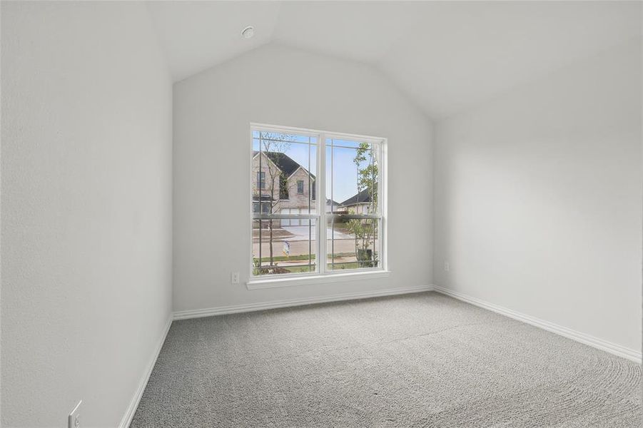 Additional living space with light colored carpet and baseboards