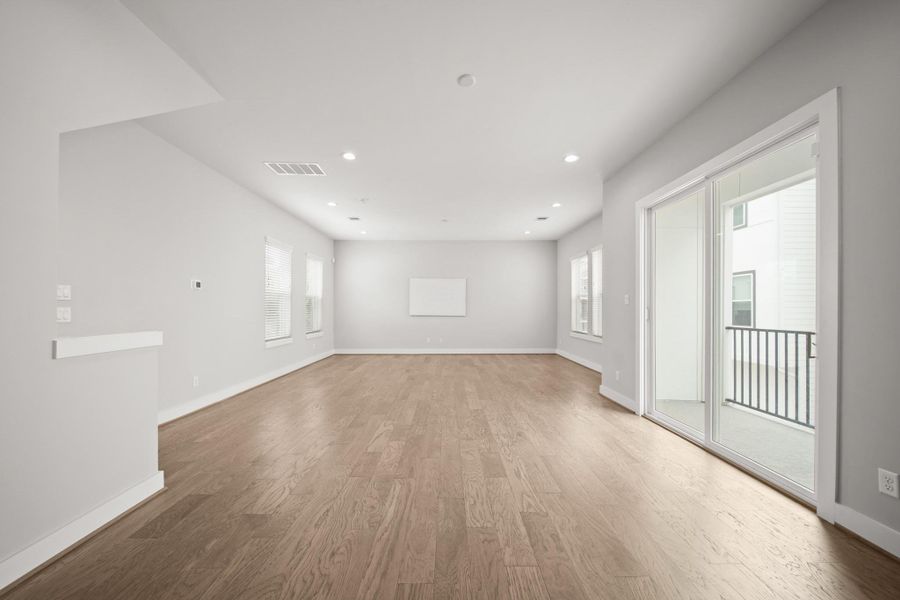 A view from the kitchen highlights the dining area and is finished with recessed lighting and wide plank hardwood flooring, giving it a warm feel and a seamless connection to the surrounding spaces. A view from the kitchen highlights the dining area and is finished with recessed lighting and wide plank hardwood flooring, giving it a warm feel and a seamless connection to the surrounding spaces.