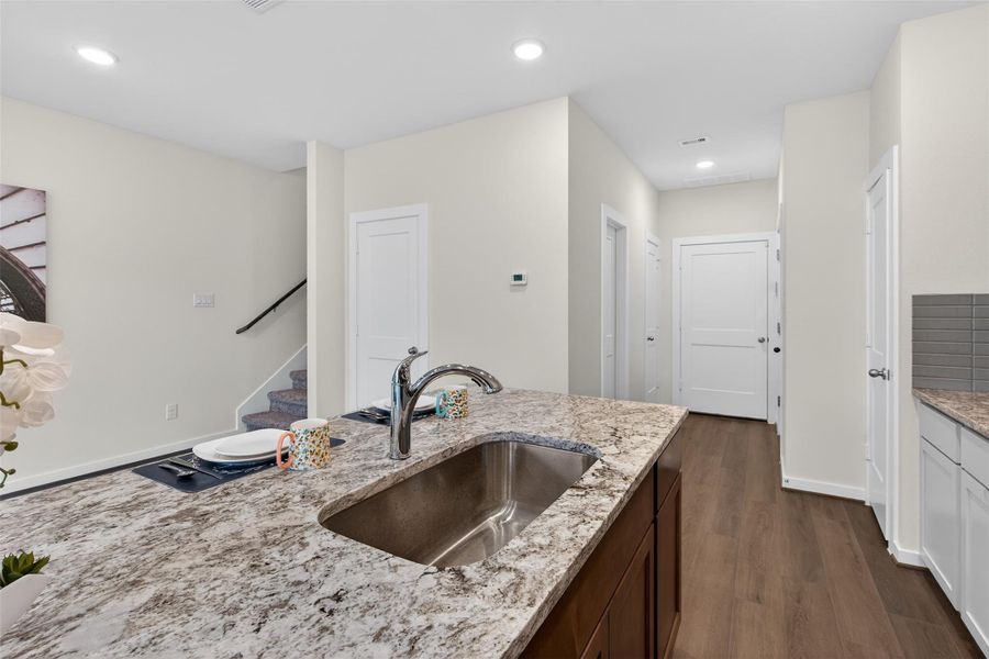 Spacious granite island with undermount sink and elegant finishes, offering a functional workspace with convenient access to the main living areas. Spacious granite island with undermount sink and elegant finishes, offering a functional workspace with convenient access to the main living areas.