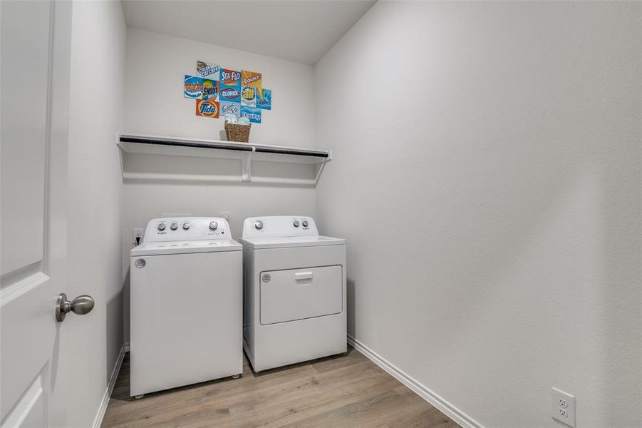 Laundry area with light wood finished floors and separate washer and dryer Laundry area with light wood finished floors and separate washer and dryer