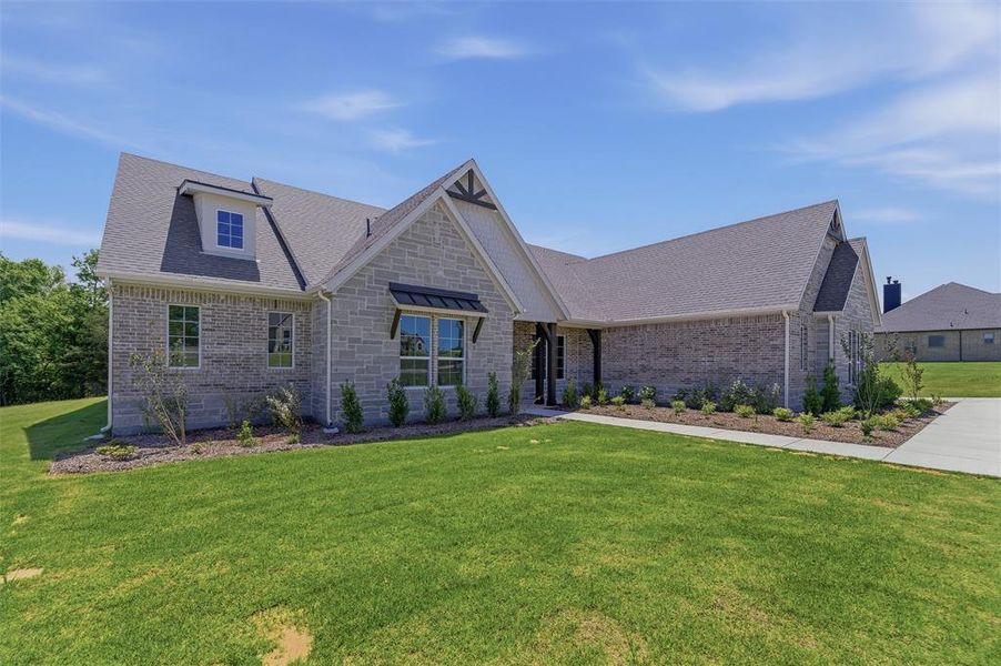 Stone and brick veneer exterior featuring a gabled roof, dormer window, and a covered porch entry