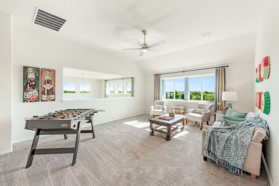 Bonus room with foosball table, seating area, carpet, and ceiling fan with large windows