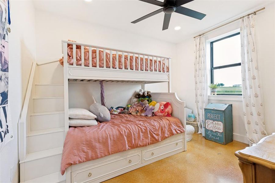 Spacious room featuring light-toned walls, a large window with ample natural light, and durable concrete flooring Spacious room featuring light-toned walls, a large window with ample natural light, and durable concrete flooring